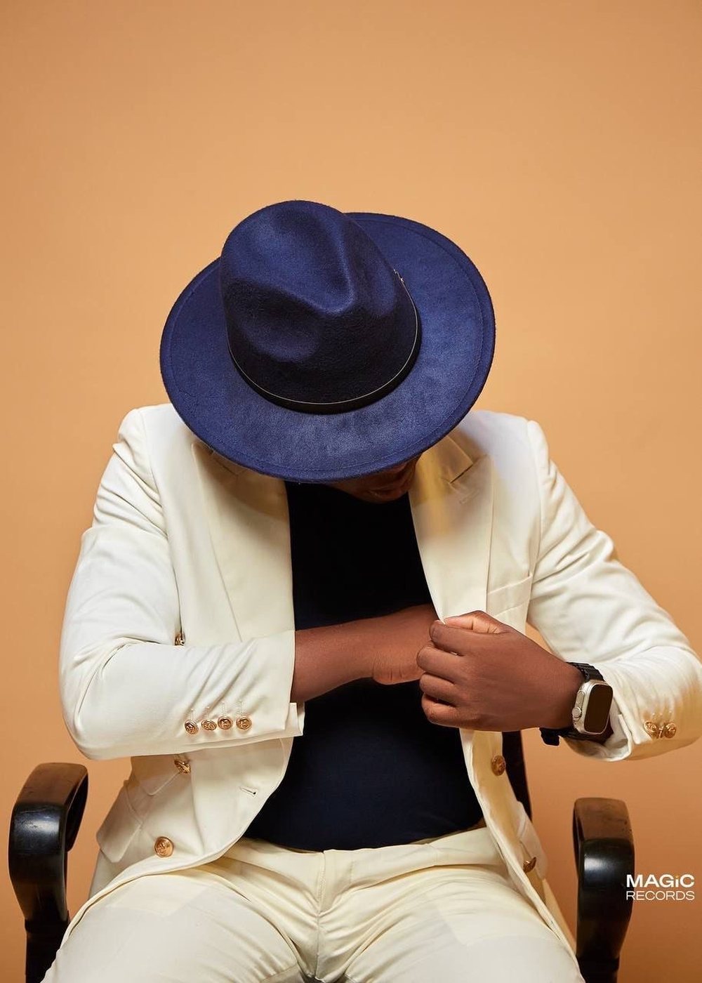 Ruben, en costume crème et chapeau bleu nuit